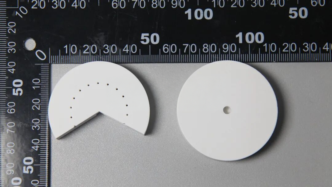 Figure 4 · Printed green bodies: complete disc on the right and sectioned part on the left; neither is debound or sintered.